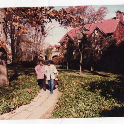 Front view of Boland Hall in autumn with women walking down sidewalk.