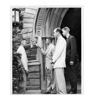 Students arriving for fall term looking at gargoyle at central arch of main entrance to Barbelin. Students include Raymond Dion, Charles T. Carr, Gilbert D. Smith, and Richard Thoden.