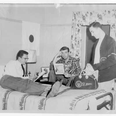 Interior view of dormitory room in Barry Hall with Charles Tymon, Myles Thomas McDonald, and William Lynch.