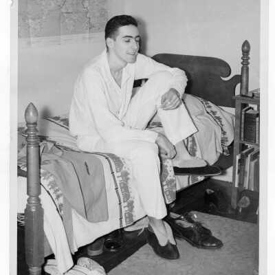 Student resident of Quirk Hall in pajamas in dormitory room.