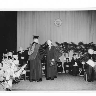 Edward G. Jacklin, S.J., congratulating honoree during 1956 graduation/commencement ceremony.