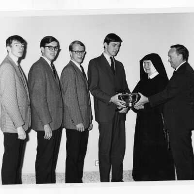 Students from Villiger Debating Society, Ronald Uzdavinis, Frederick Brodzinski, Eugene Comey, and Wayne Barrett, receiving award at Rosemont College Debate tournament.