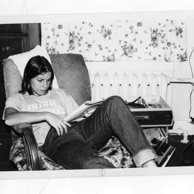 Woman student studying in dormitory room next to phonograph record player.