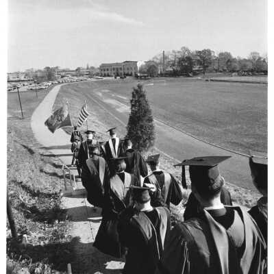 Graduates processing alongside Finnesey Field to Field House.