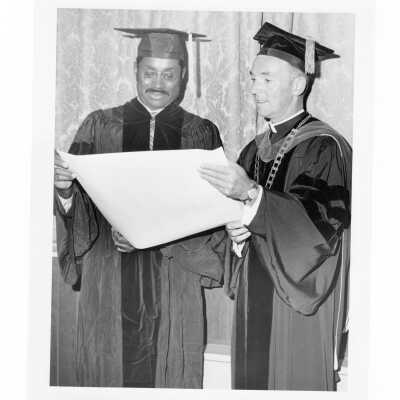 Terrence Toland, S.J., with honorary degree recipient, Marcus A. Foster (?) during September 1970 graduation/commencement.