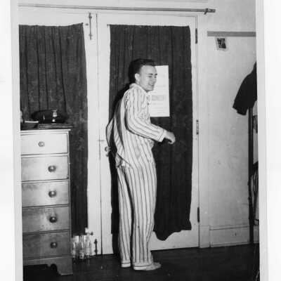 Student resident of Barry Hall in pajamas in dormitory room.