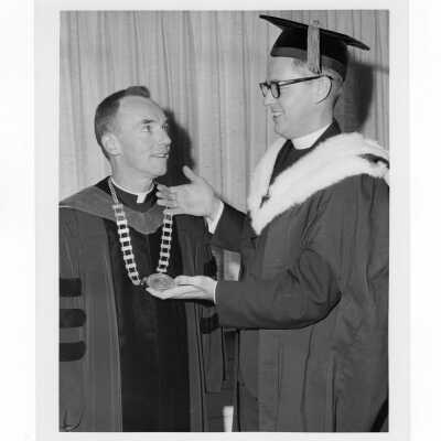 Inauguration of President Terrence Toland, S.J., November 14, 1968. Before ceremony, Toland and Jerome Coll, S.J. try out Chain of Office in a picture-taking session.