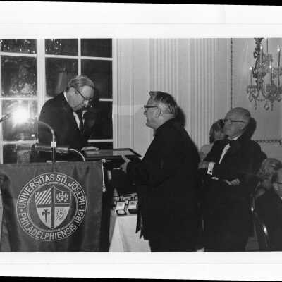 Paul E. Kelly receiving alumni award from Al Jolson, S.J., c. 1980.