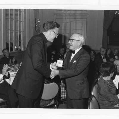 Donald I. MacLean, S.J., presenting award to Francis deSales Stokes, M.D., at alumni awards dinner, c. 1980.