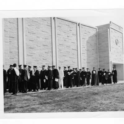 Faculty processing in front of Villiger Hall toward Field House for 1965 graduation/commencement.