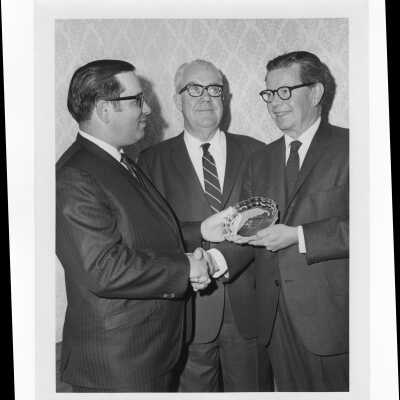 Richard J. Hughes receiving Law Alumni Award with two other individuals watching, December 2, 1969.