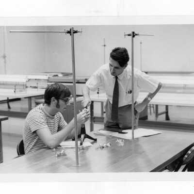 Student working with professor in science laboratory.
