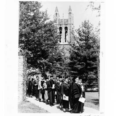Faculty processing to Gest Lawn during 1976 graduation/commencement ceremony with Barbelin Hall in background.