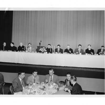 View of head table at alumni communion breakfast, October 30, 1955, with Fr. McNamara, Fr. Leary, Hunter Guthrie, S.J., Charles Krull, Edward G. Jacklin, S.J., Frank Lammer, Joseph S. Hogan, S.J., James Duffin, Matthew Sullivan, S.J., Richard Carroll.