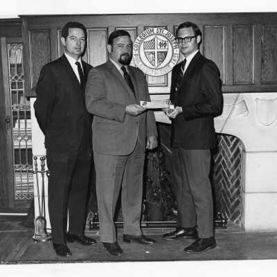 B. Thomas Blady receiving award from William Roth of Great Books of the Western World division of the Encyclopedia Britannica, with Dr. George E. Brown, assistant professor of philosophy watching.