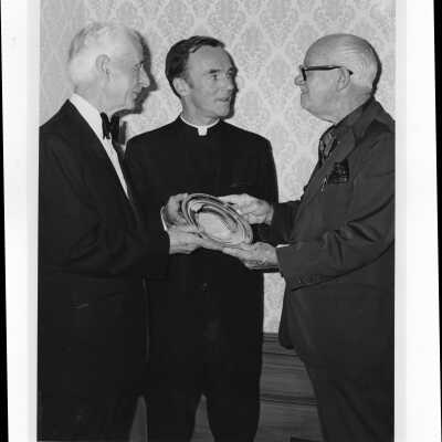 Terrence Toland, S.J., and another individual congratulating Jerry Doyle, recipient of Law Alumni Award, Crim-Gray Award, November 16, 1971.