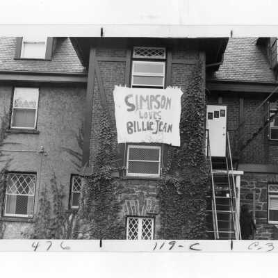Exterior view of Simpson Hall with sign hanging from window stating, "Simpson loves Billie Jean."
