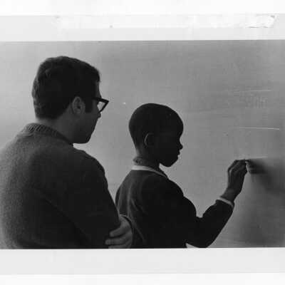 Student tutoring child at Rhoads Public School (?) as part of community service/outreach project. (Peace and Human Development program?)
