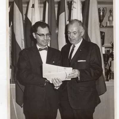 C. Allan Stewart and Dr. C. Richard Arena look over program of activities during Pan American Observance, c. 1966.