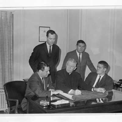 Lawrence R. McHugh, S.J., with Joseph Pascucci and others looking at blueprints.