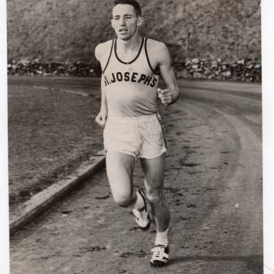 Track team member running on track.