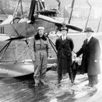 First air mail Victoria to Seattle, pictured are Eddie Hubbard and Postmaster Bishop with umbrella, Oct 15, 1920. Reproduction (1998) of photograph by J. Howard Chapman (1861-1942): From Royal B.C. Museum and Archives (A-06814)