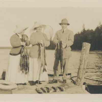 Three people on a dock