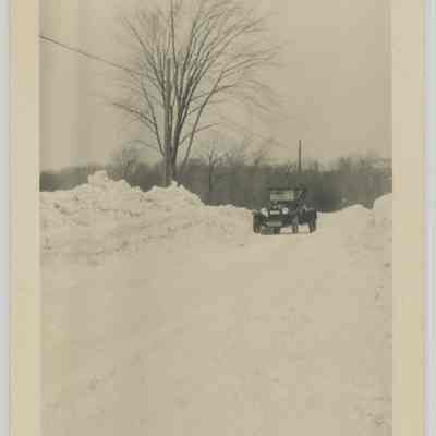 Historic Car Driving Down Snow-covered Road