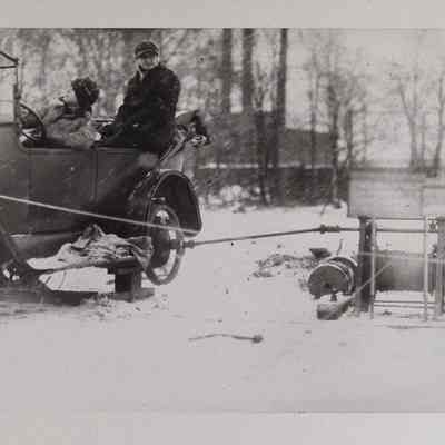 Two men in an automobile modified to power a winch