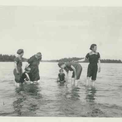 Women and children swimming in a lake