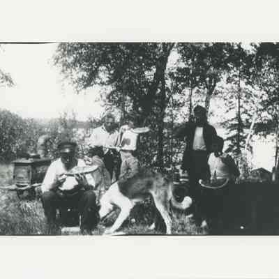 Men eating watermelon near the lake