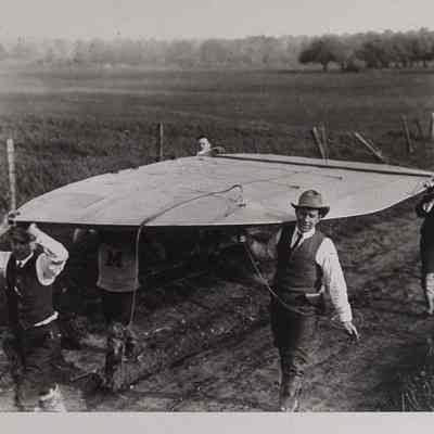 Men carrying a dirigible rudder
