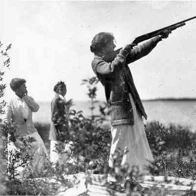 Woman shooting a shotgun