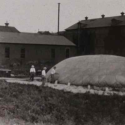 Three men with partially inflated observation balloon