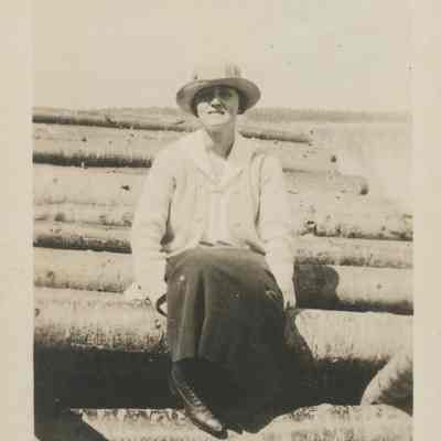 Woman on stacked logs