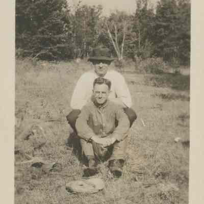 Two men sitting in a meadow