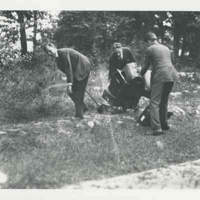 Men struggling with luggage on a small cart