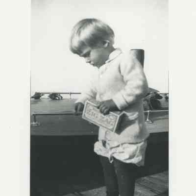 Child on a dock with a boat