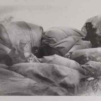Three men deflate an observation balloon