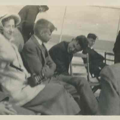 Group of young people sitting on deck of ship