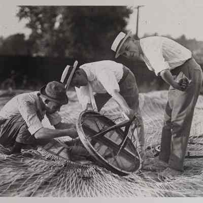 Three men working on deflated balloon