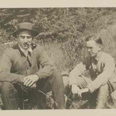 Three men sitting in a meadow