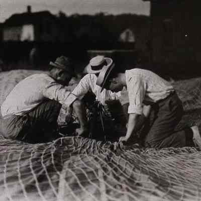Three men working on deflated balloon