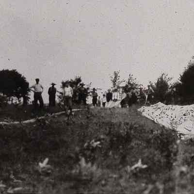 Group of men in a field with a deflated balloon