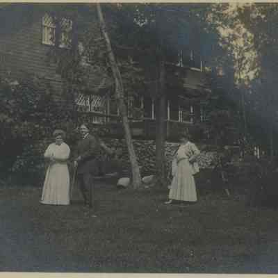Group of people on the lawn at the Main Cabin of Cedar Lodge