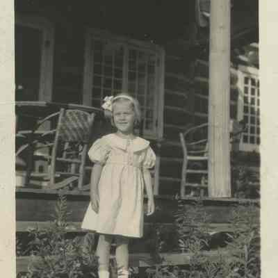 Gertrude F. Harrison standing on the steps at Cedar Lodge