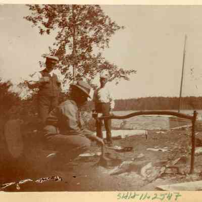 Three men at a cookfire