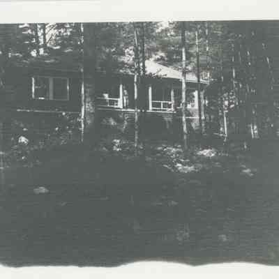 A man on the porch of a cabin