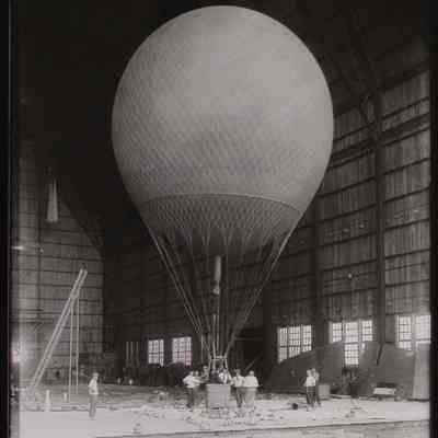 Round balloon with basket inside hangar