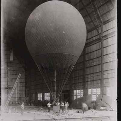 Round balloon with basket inside hangar